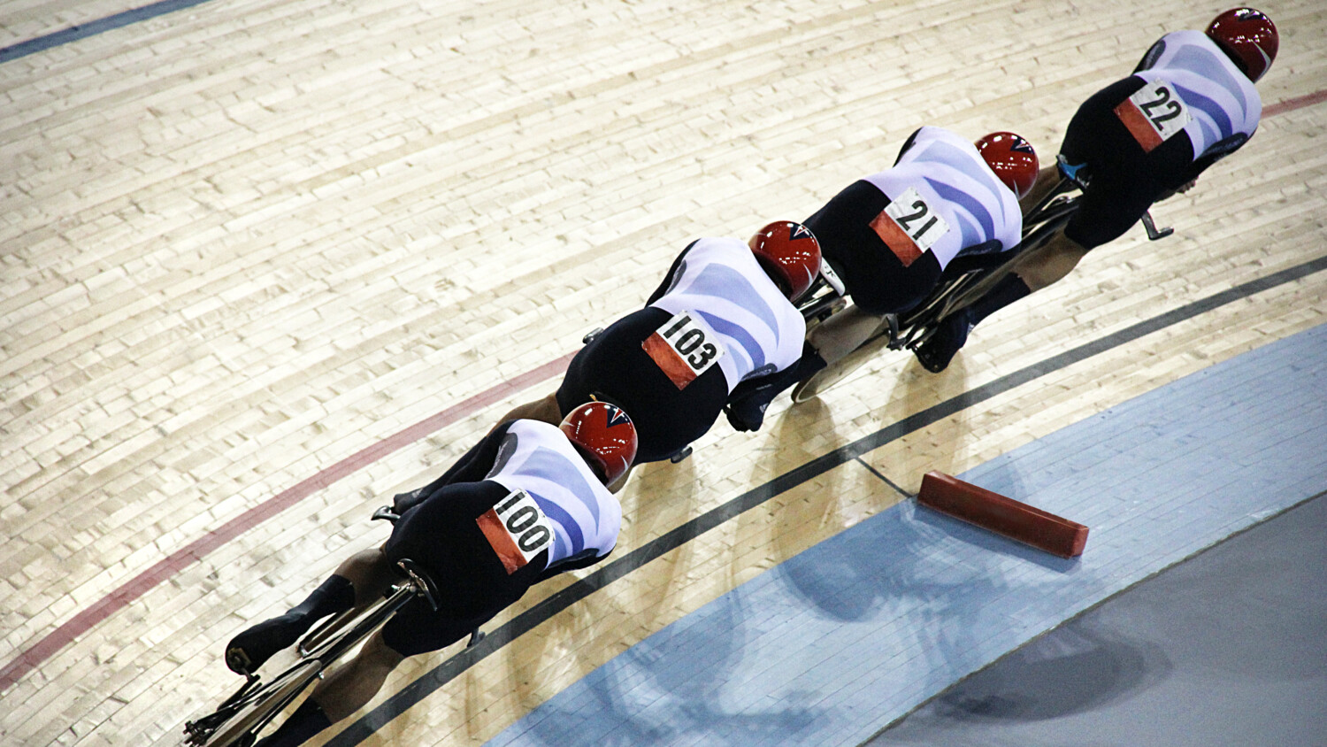 Cyclists in an indoor velodrome competition.