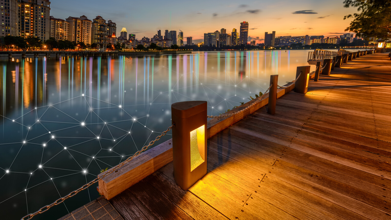 Boardwalk at sunset with city view and network overlay in the water.