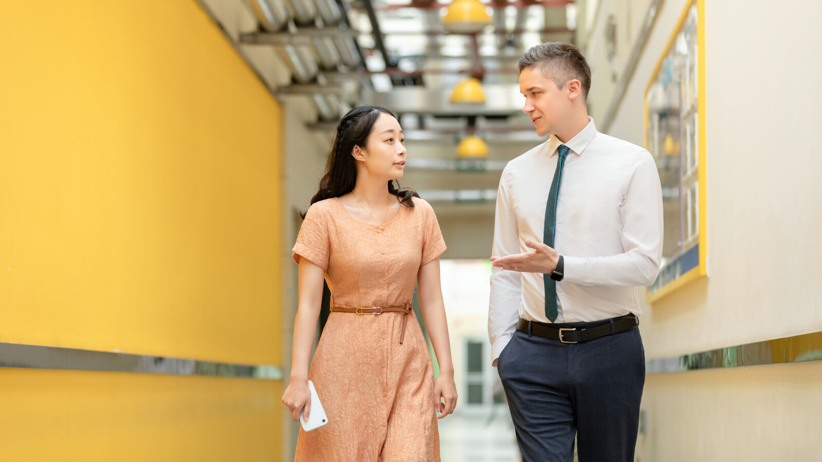 Man and woman walking in a hallway of Ericsson 5G Factory Nanjing.