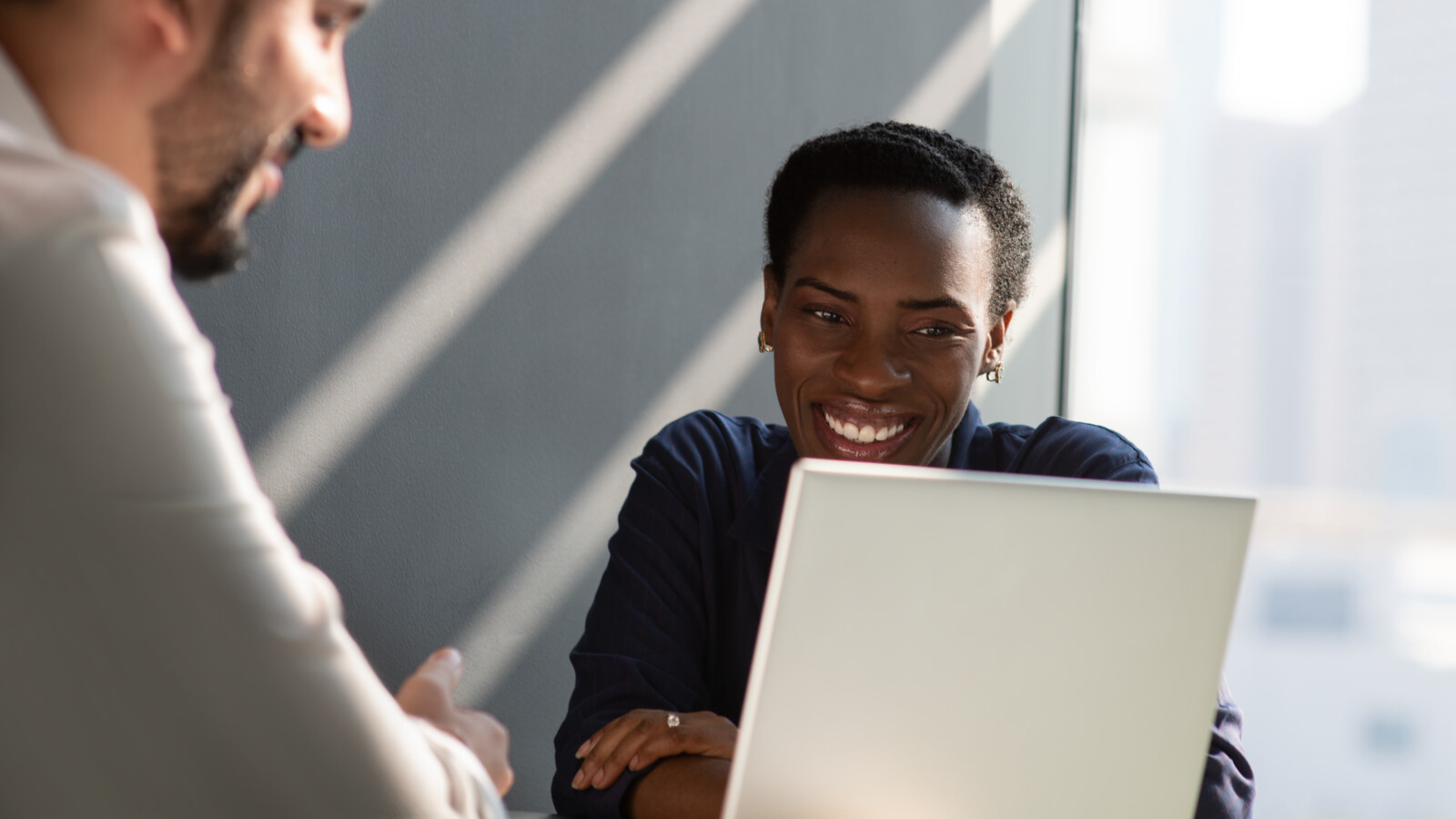 Two colleagues are working on a laptop.