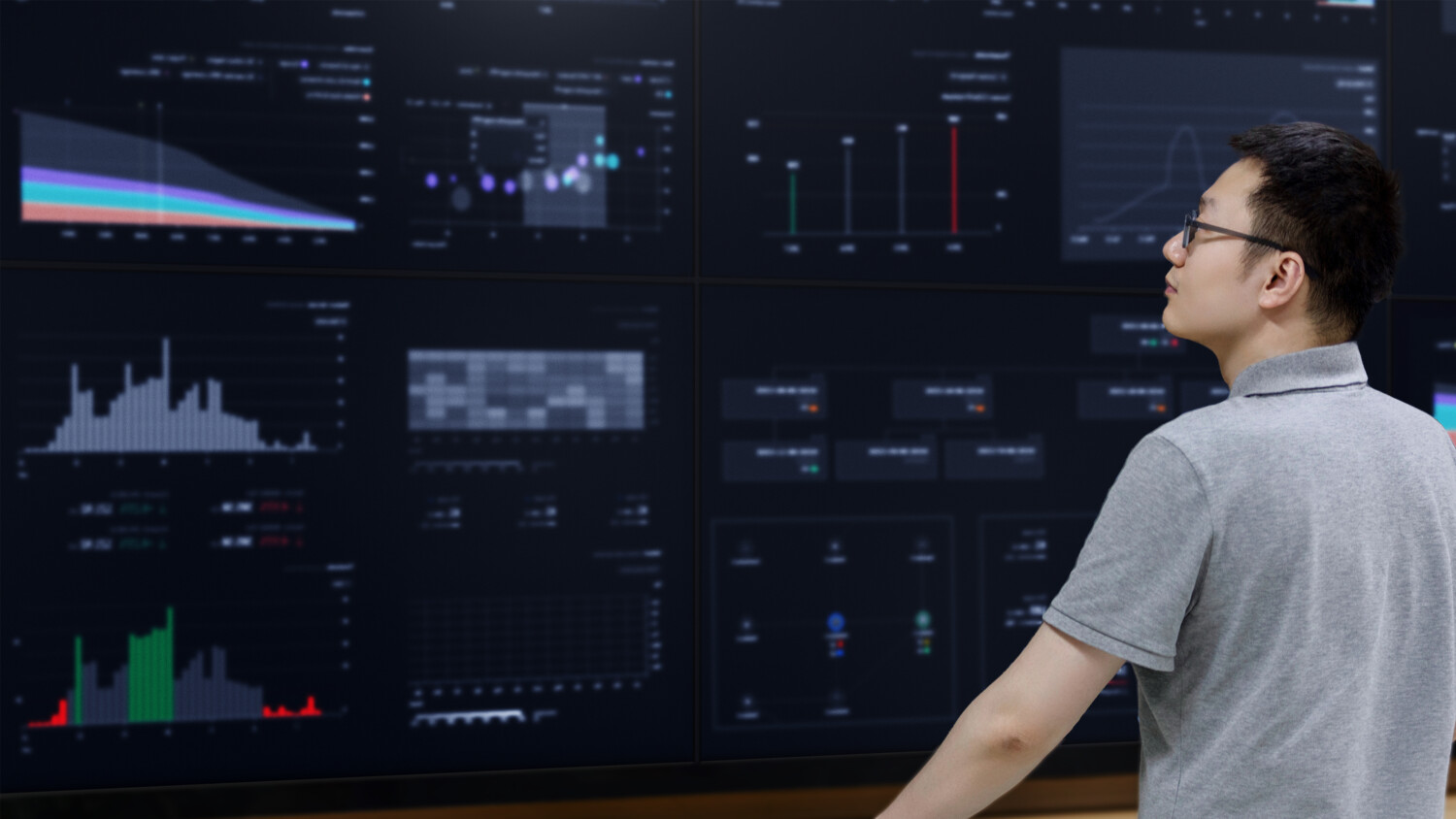 Man looks at screens.