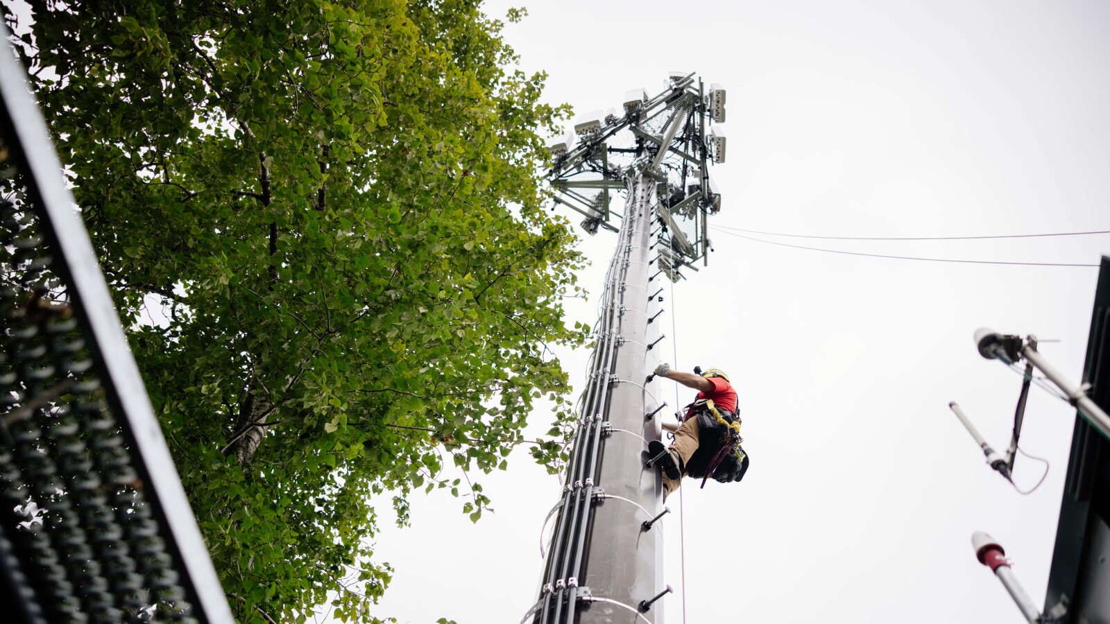 Worker climbing to reach an antenna