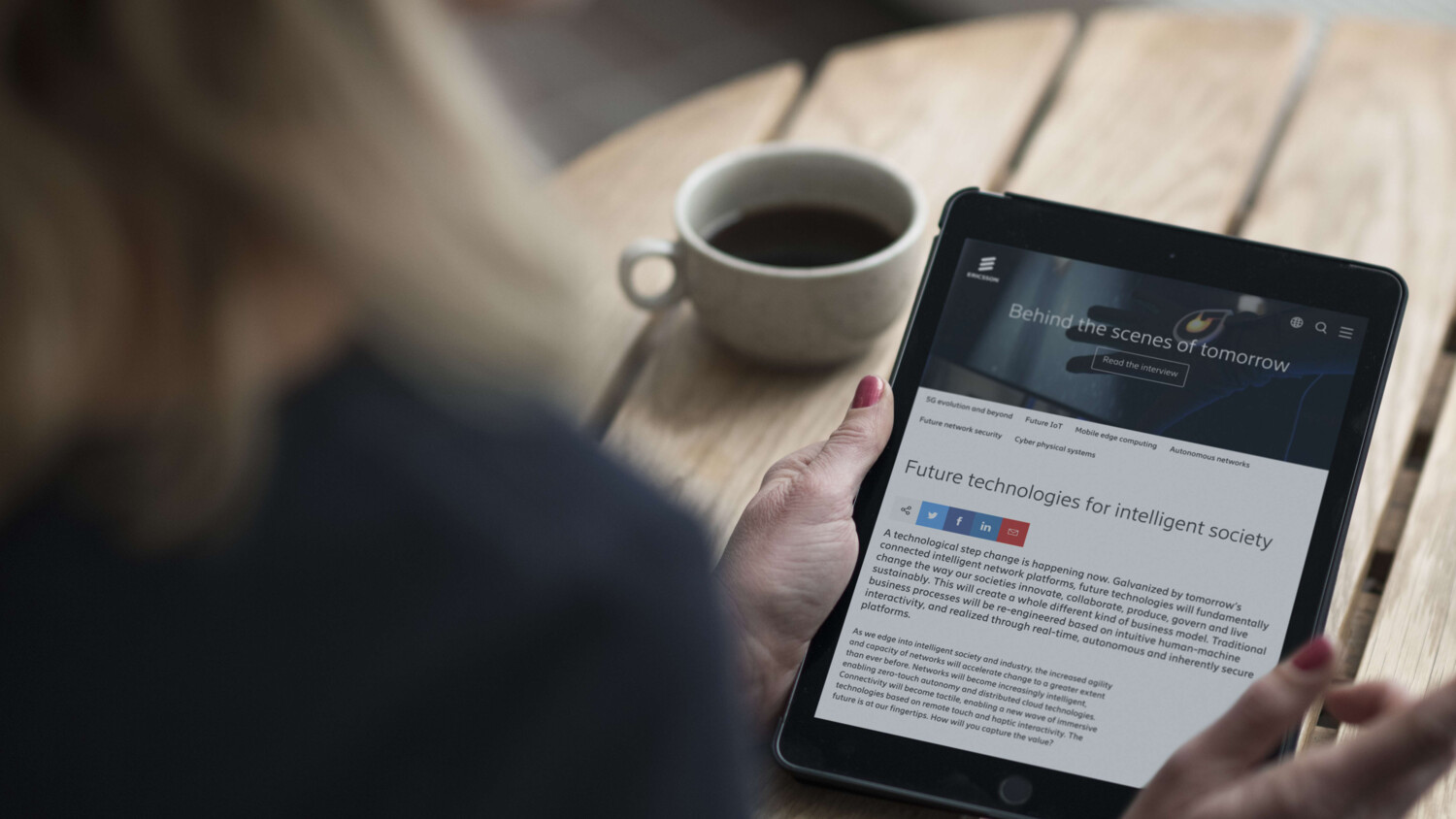 woman sitting at a table with a tablet. 