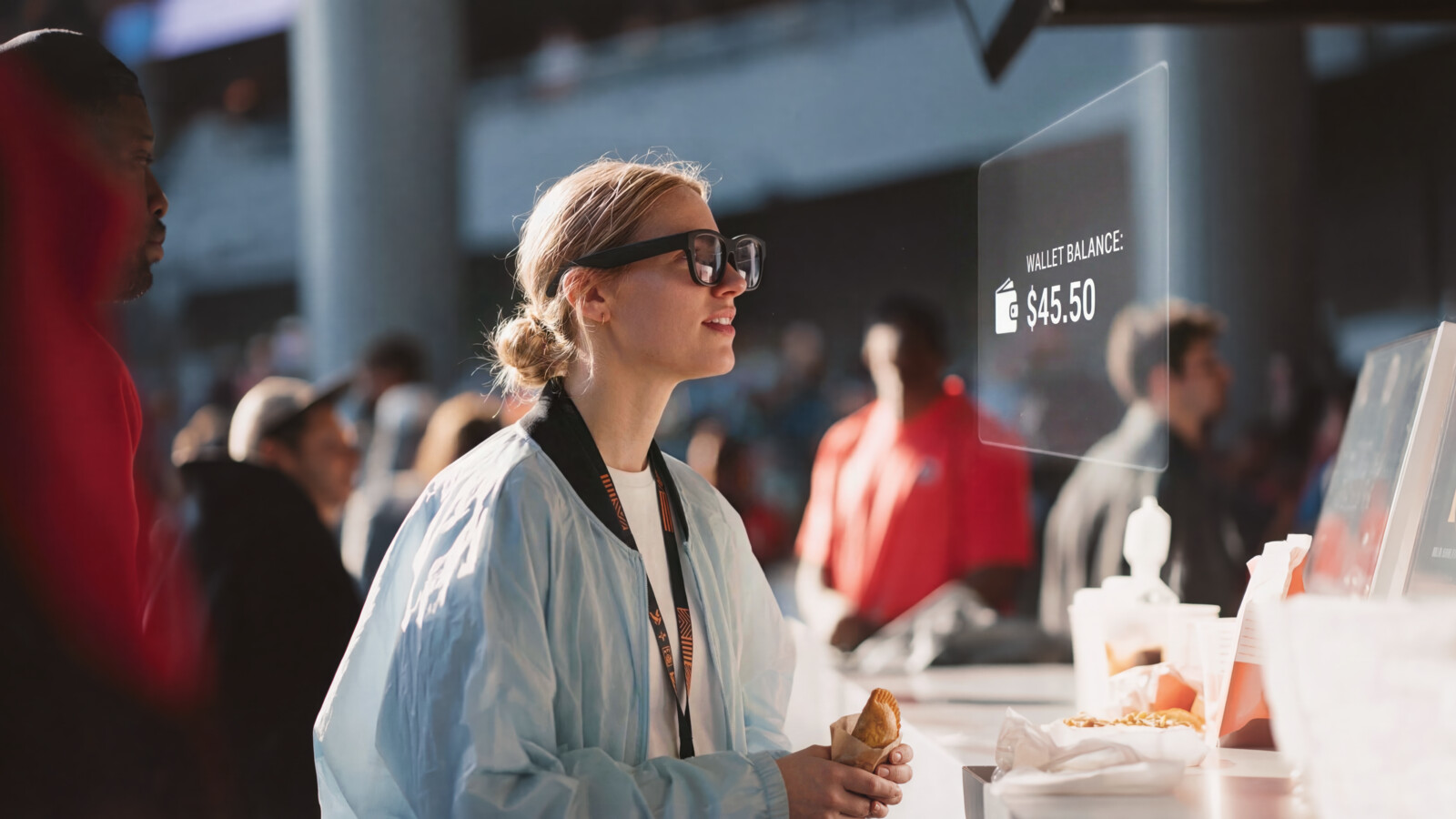 Woman checking digital wallet balance at food stand in crowded venue