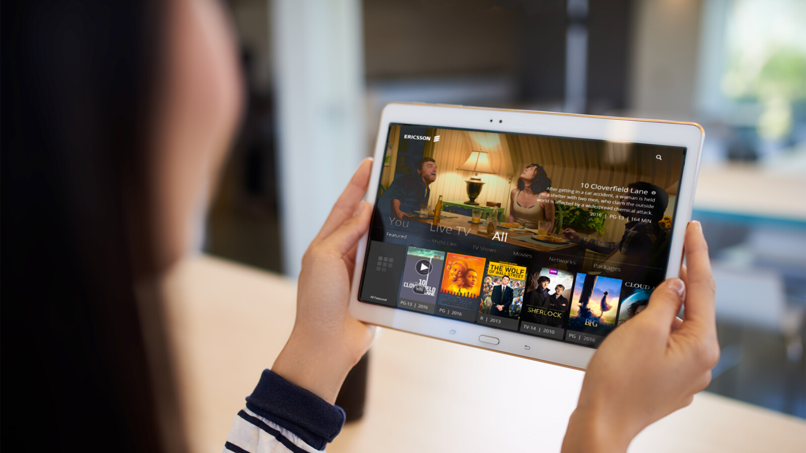 Person holding a tablet displaying a streaming service.