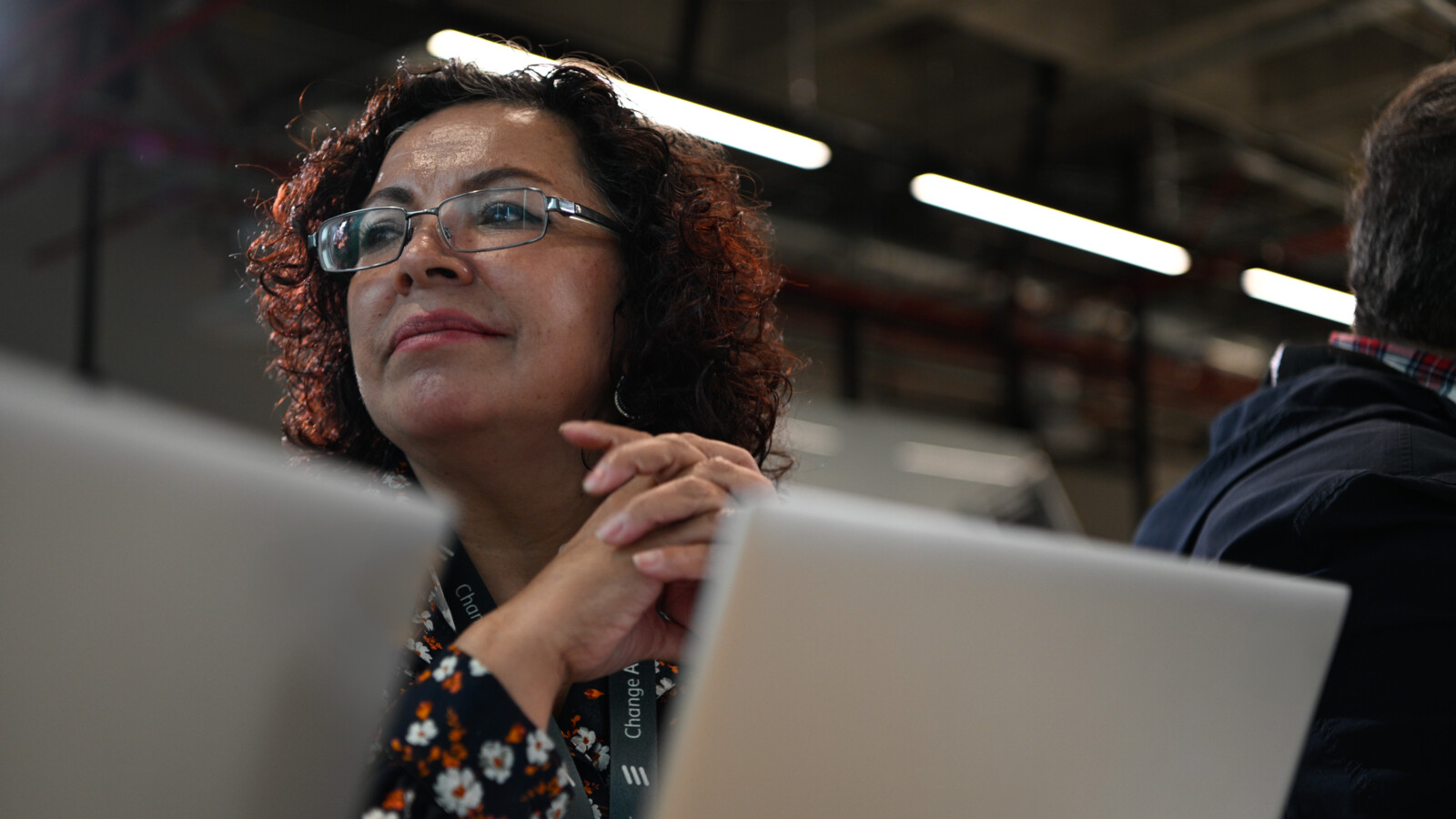 A woman sitting in front of laptop in a meeting.