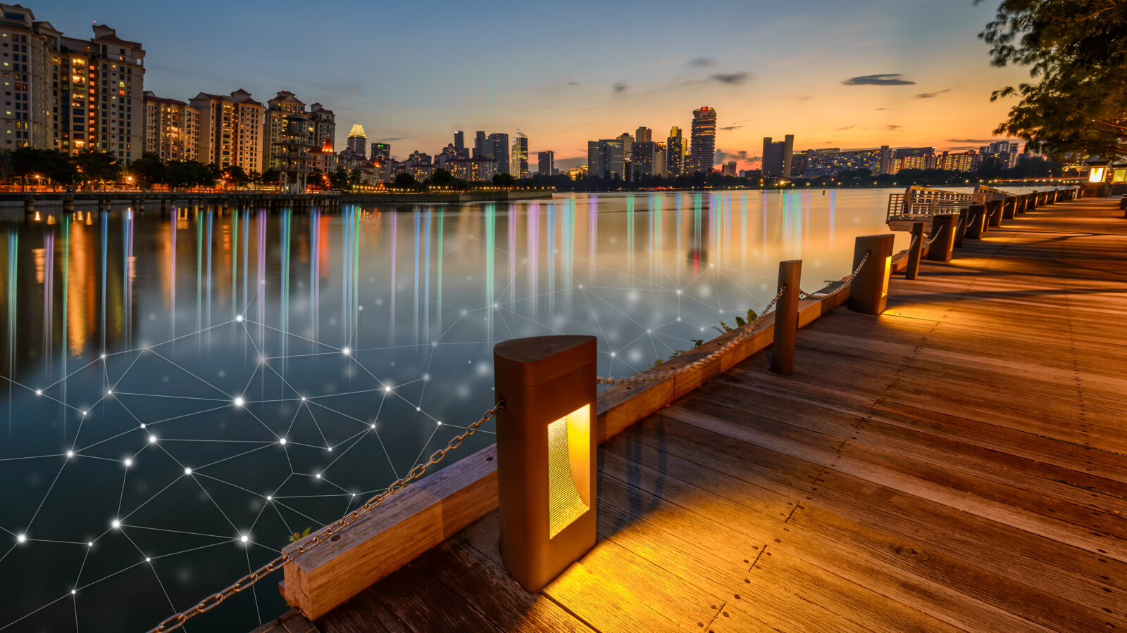 Waterfront promenade at sunset with cityscape and digital overlay.