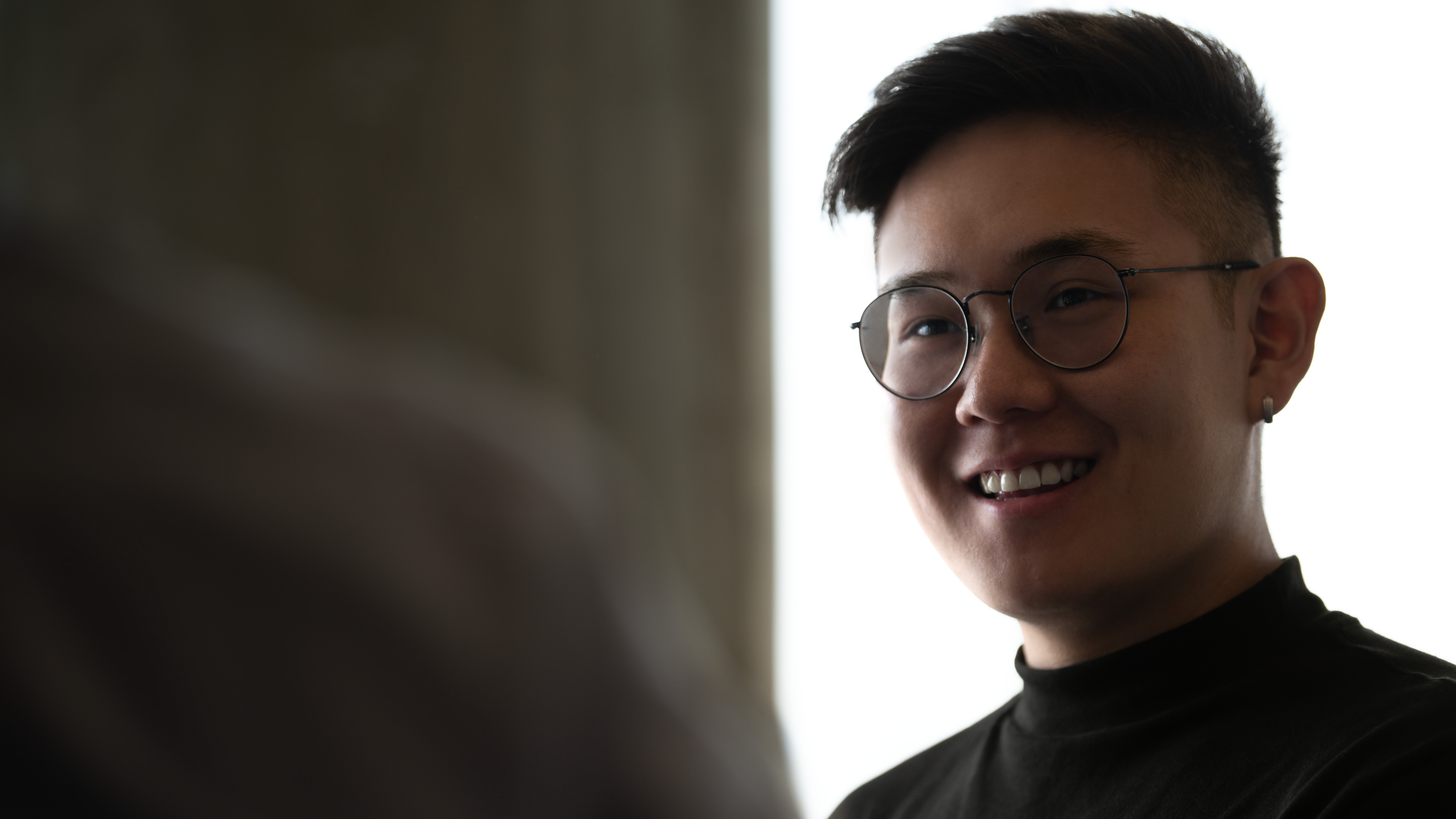 Man smiling at coworker.