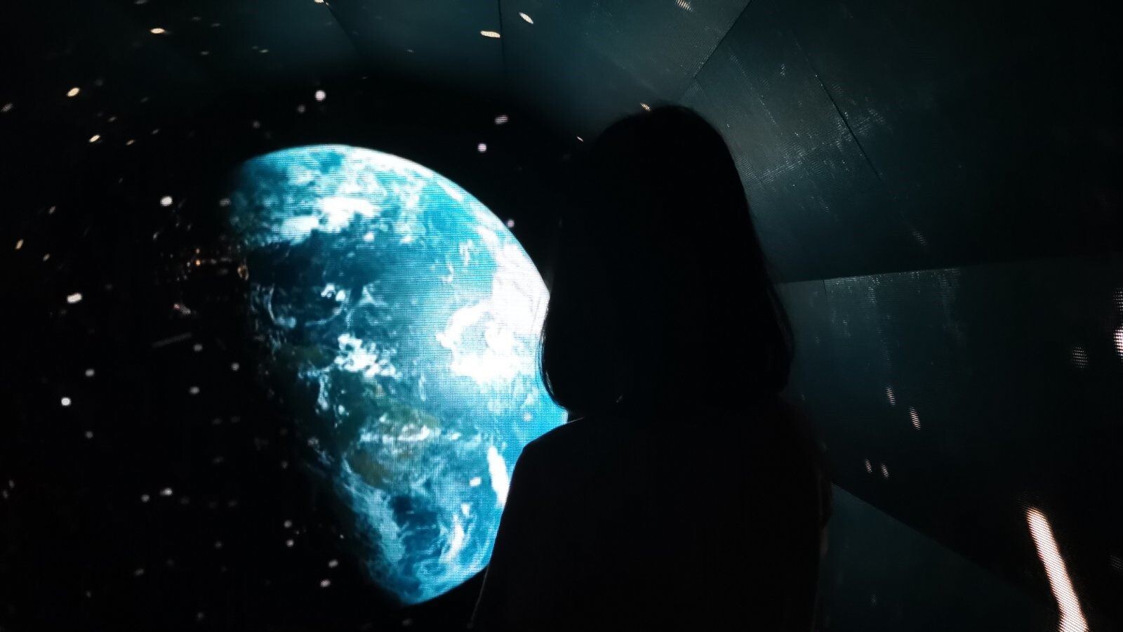 A girl looking at the planet in the dark sky