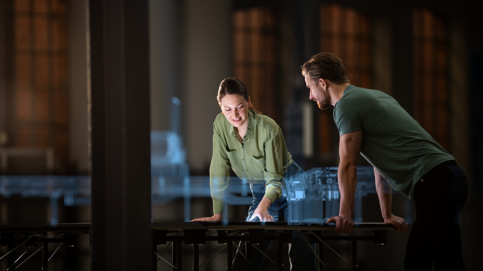 Colleagues discussing 5G industry project using a holographic model of a digital twin