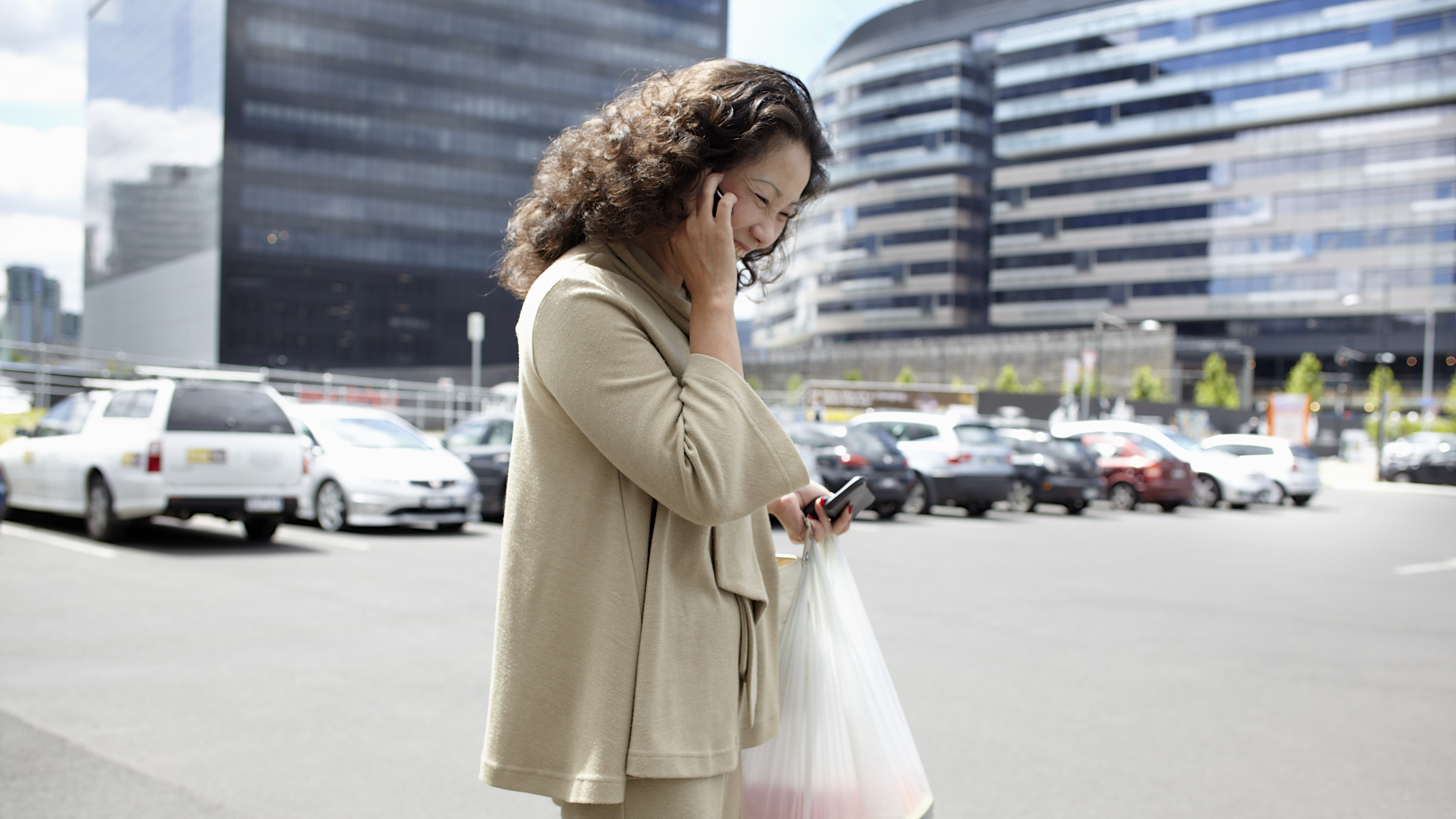 woman standing in parking lot talking on the phone