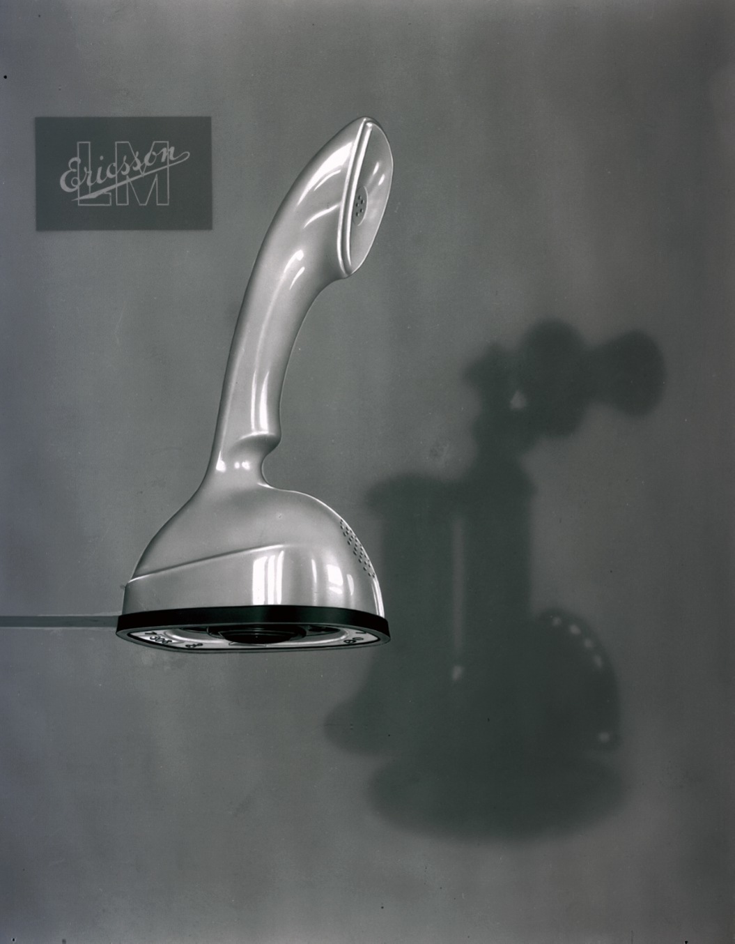 Ericofon with the shadow of an earlier telephone model. Cover image from Ericsson’s 1956 Annual Report.