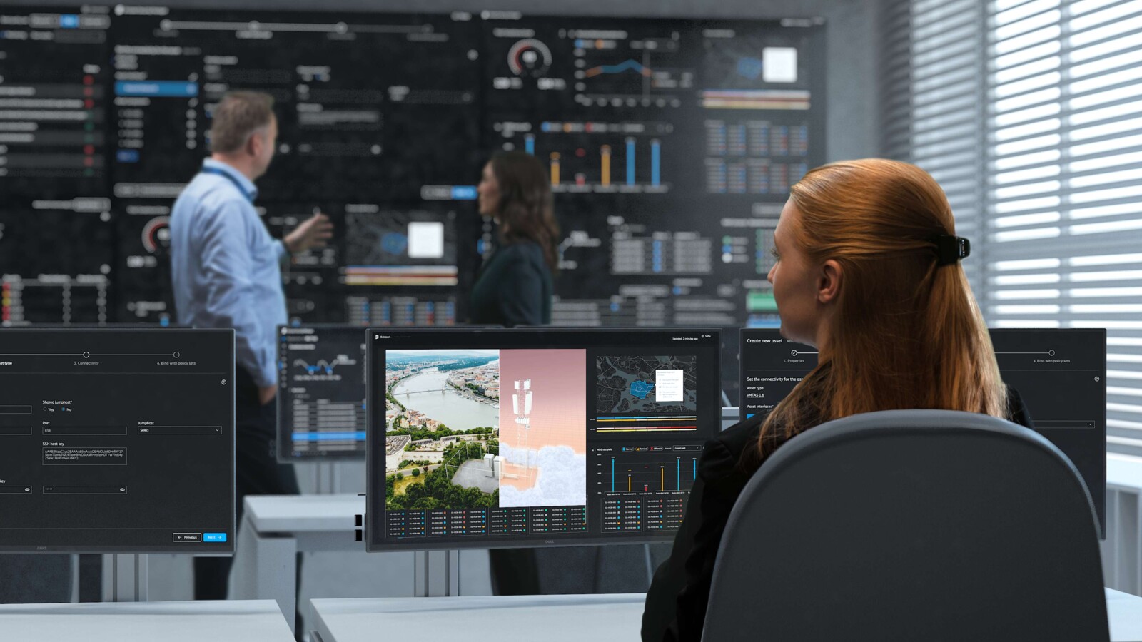 People working in front of multiple screens in a Network and/or Security operation center.