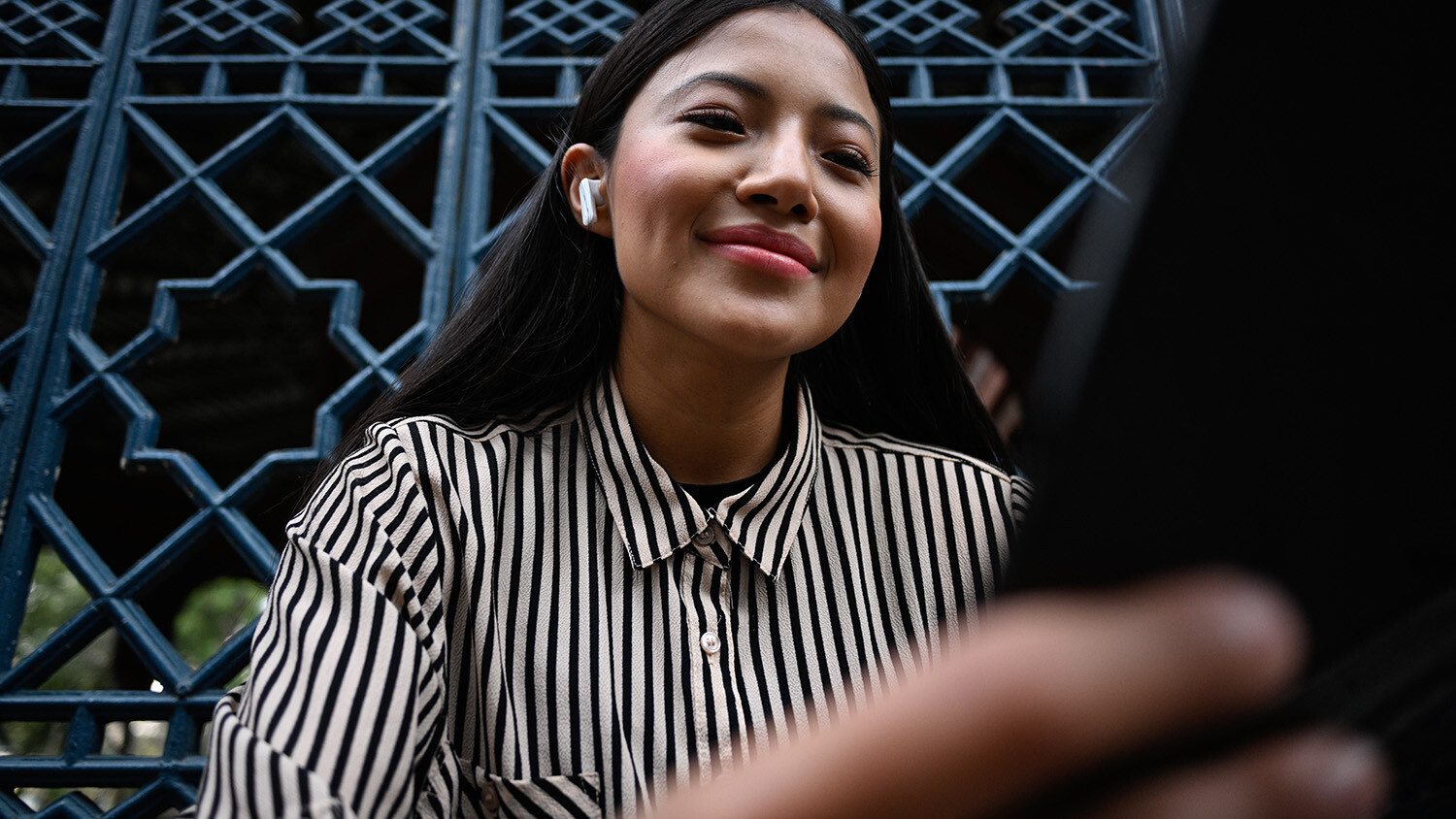 Woman smiling during video call on tablet.