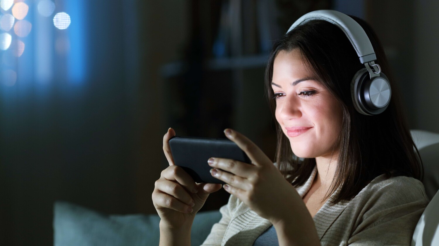 Woman with headphones watching video on smart phone