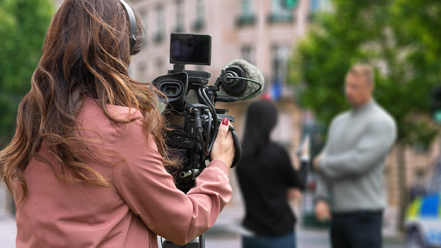 Videographer films street interview with two people