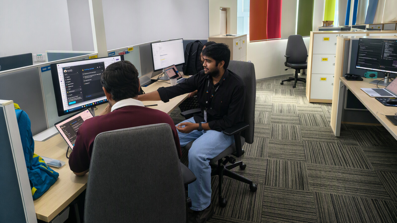 Purval working at their desk with a colleague.