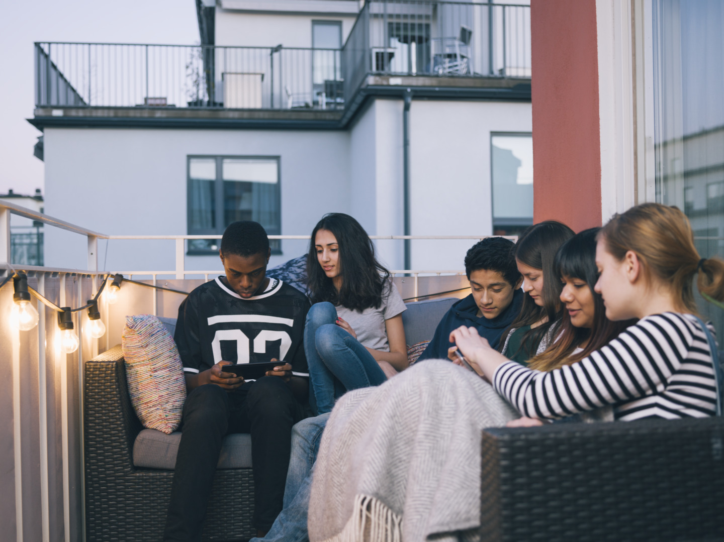 Image_Teenagers looking at media on a balcony