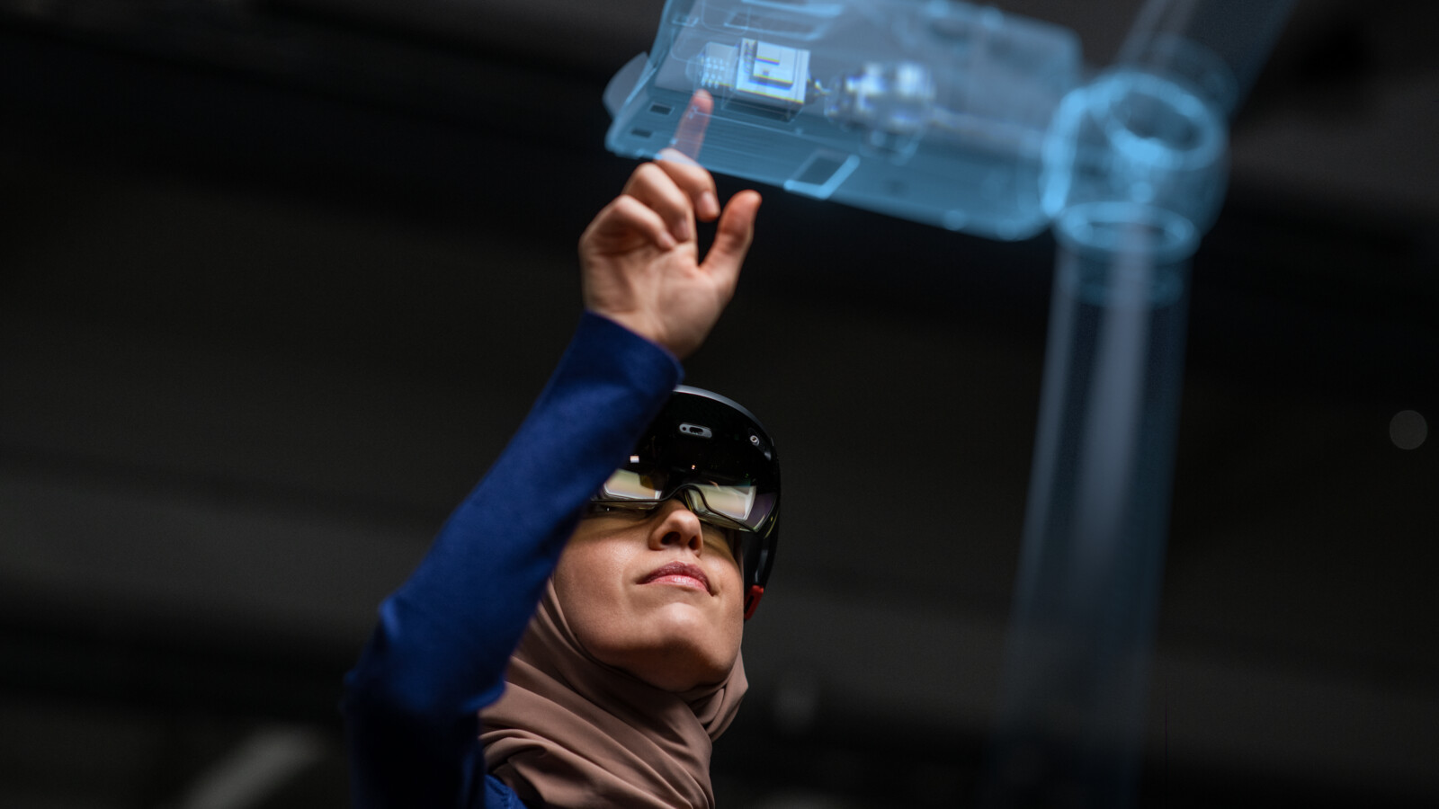 A female industry worker with AR glasses working on hologram