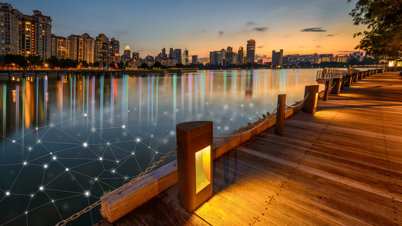 Boardwalk at sunset with city view and network overlay in the water.