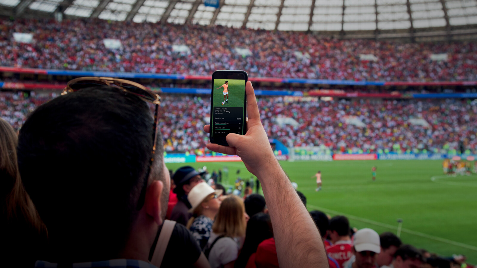 Fan using their phone to take photos in a stadium