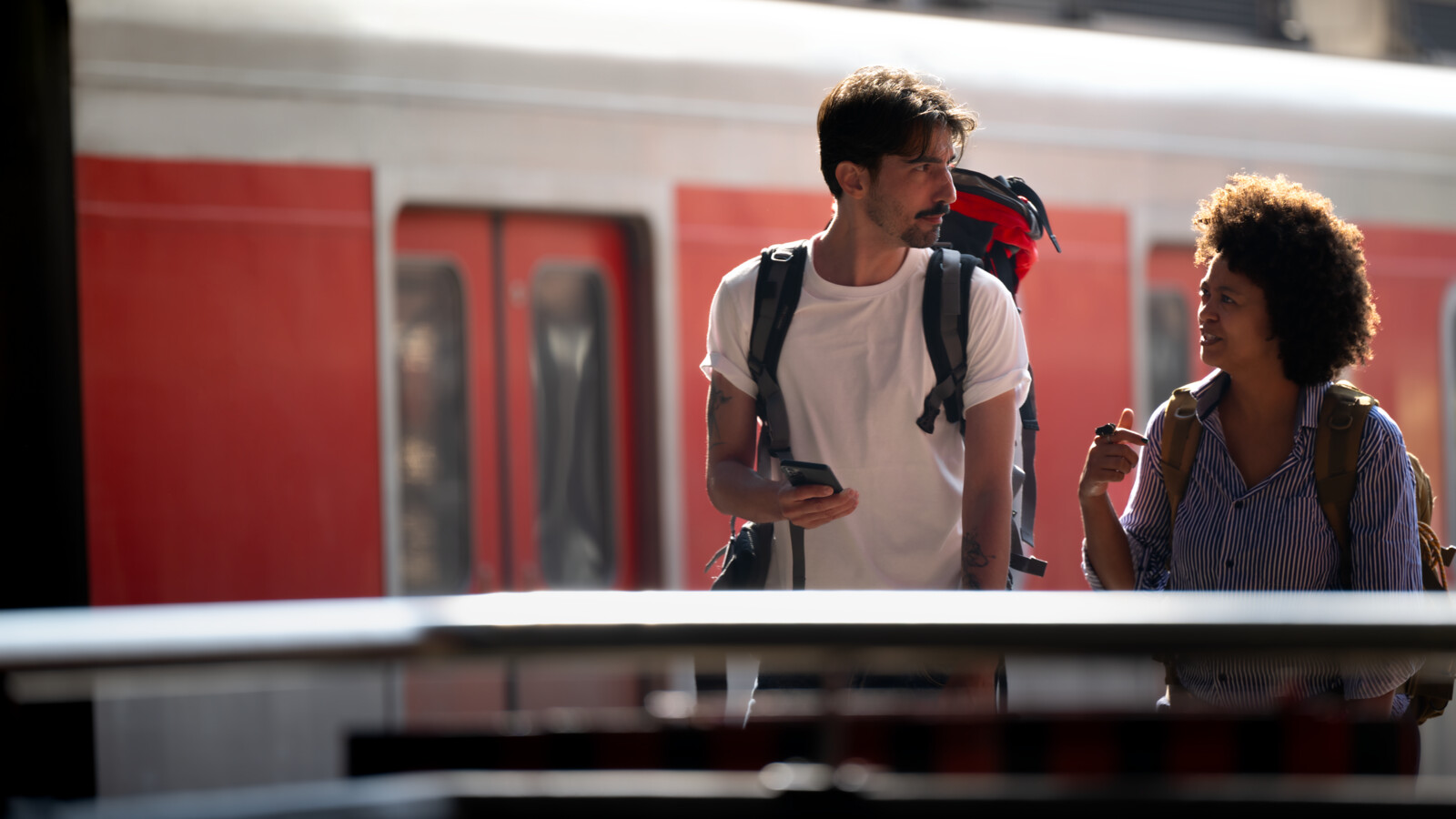Backpackers walking and talking on train station