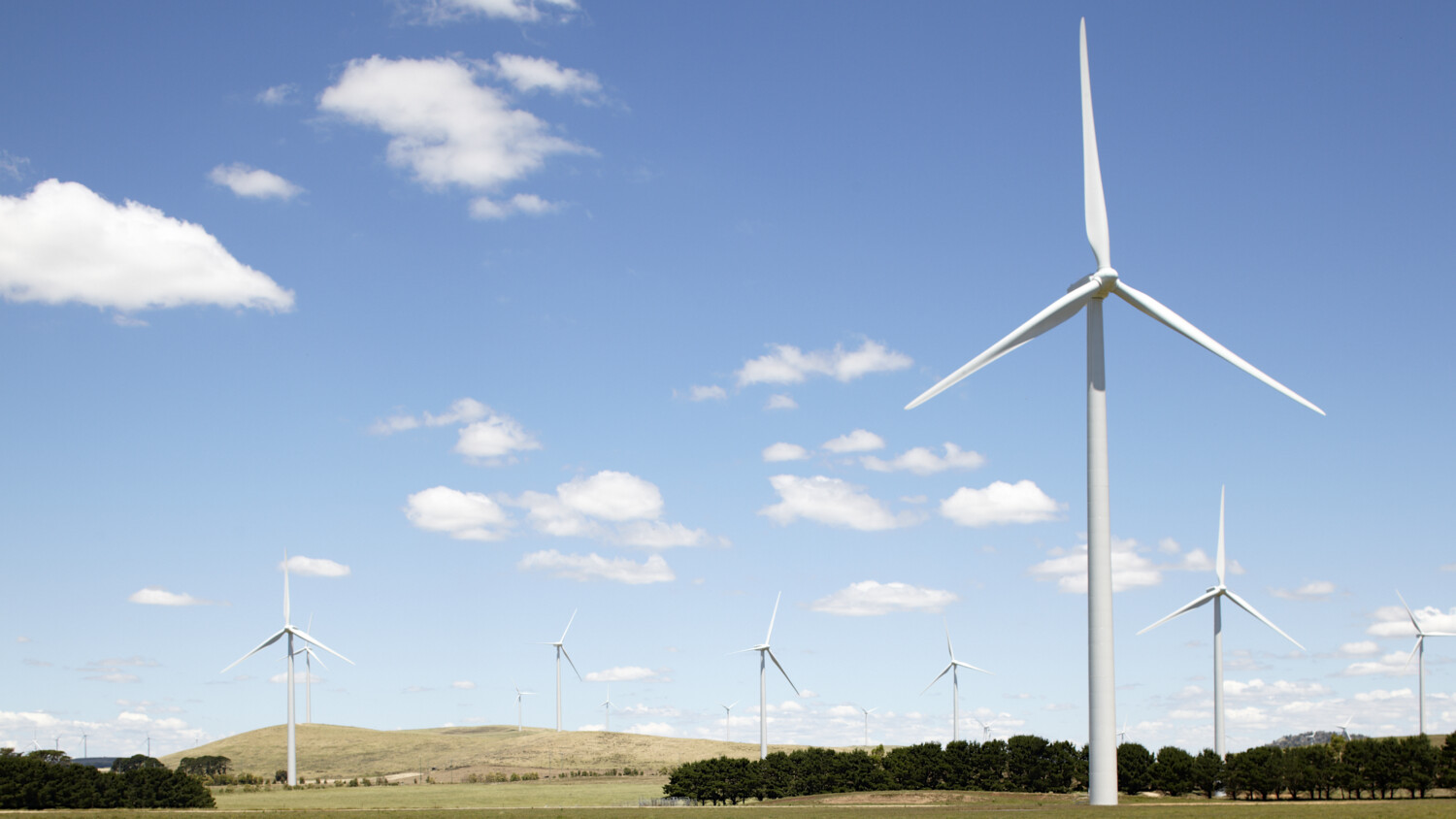 Wind turbines on grassy hills.