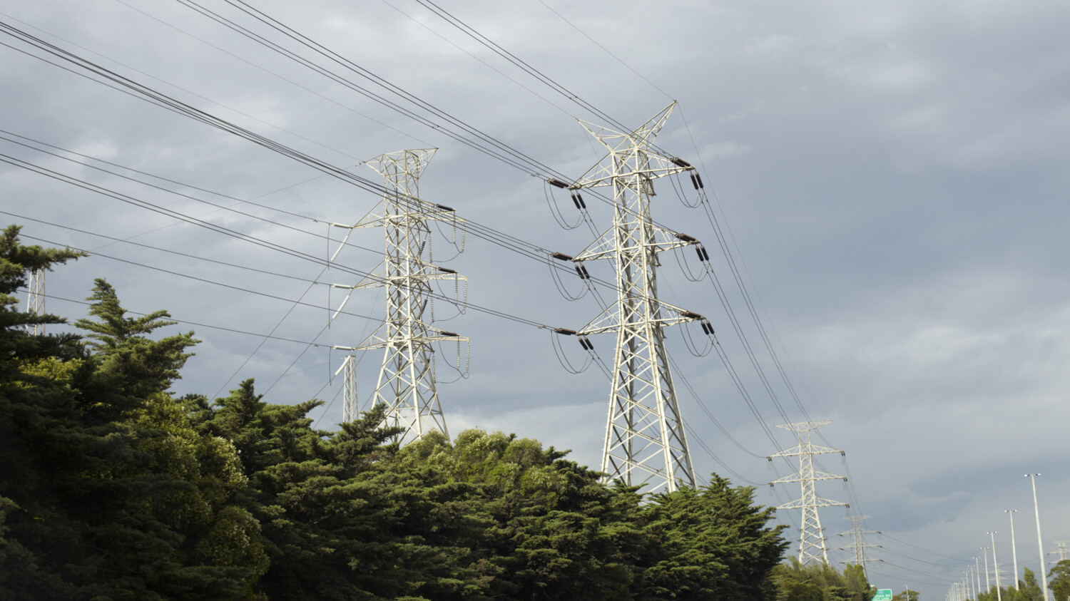 Tall power tower in green landscape.