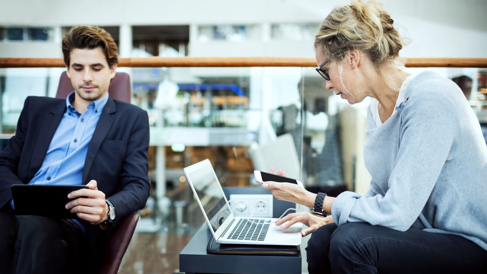 People working using laptop and phone at the airport transit hall