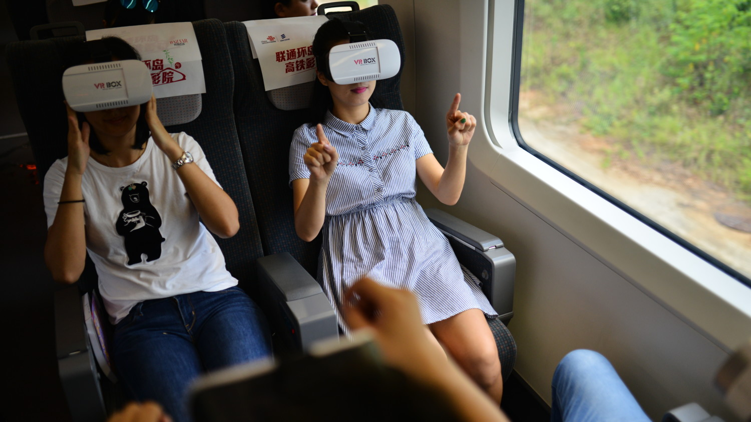 People on a train using VR goggles
