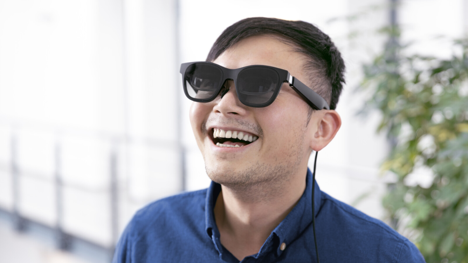 Young asian man is wearing VR-glasses and enjoys visualization