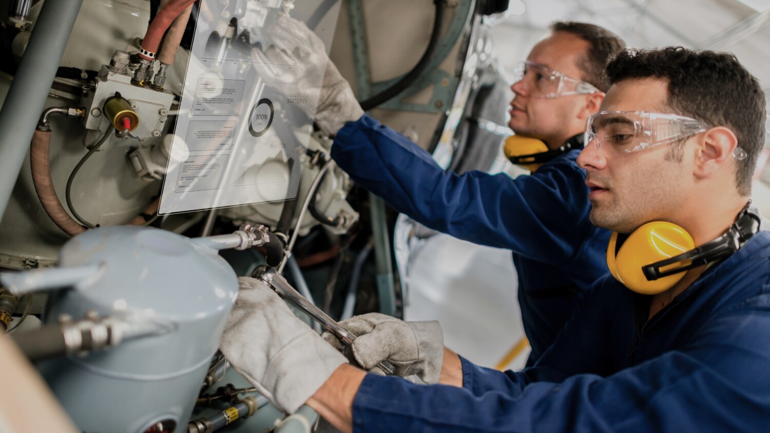 Two airplane technicians make repairs using augmented reality enabled by 5G.