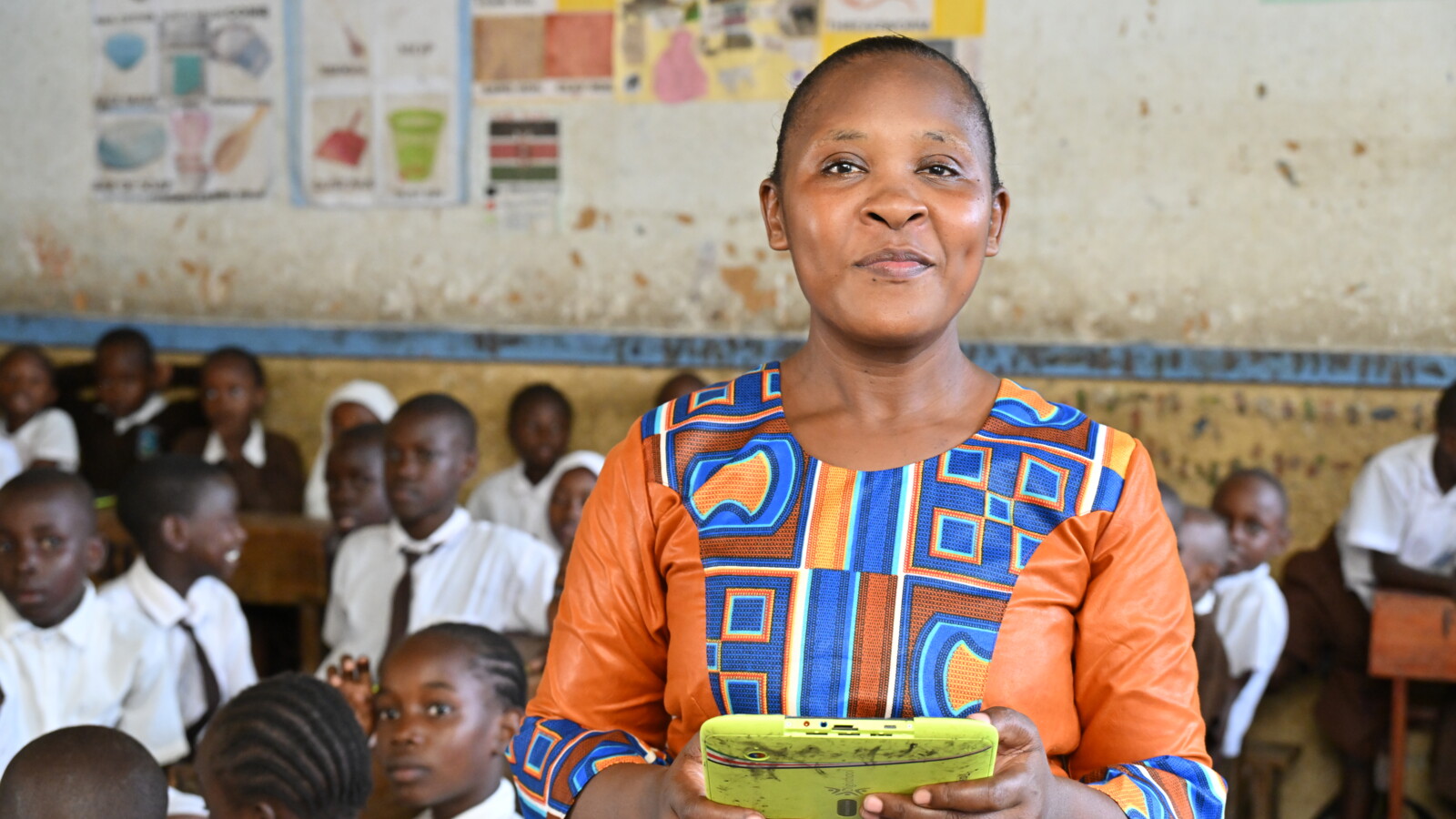 アマニ総合学校の教師であるクリスティンは、オンライン教材を使ってクラスを教えています。