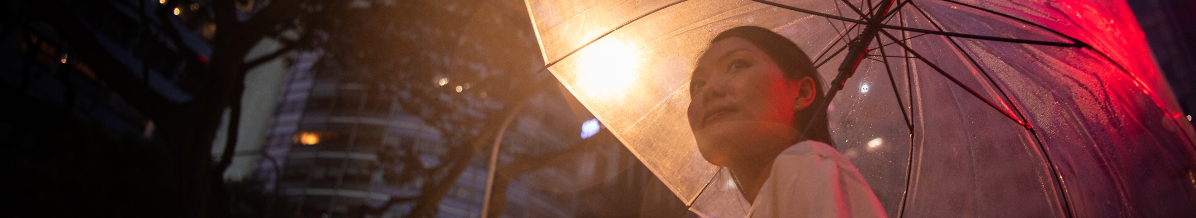 A woman with an umbrella holding a mobile