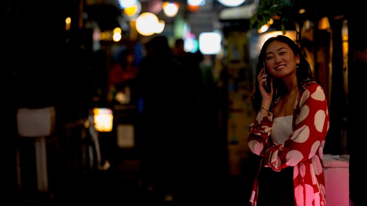 A woman talks on her phone on a street in Japan