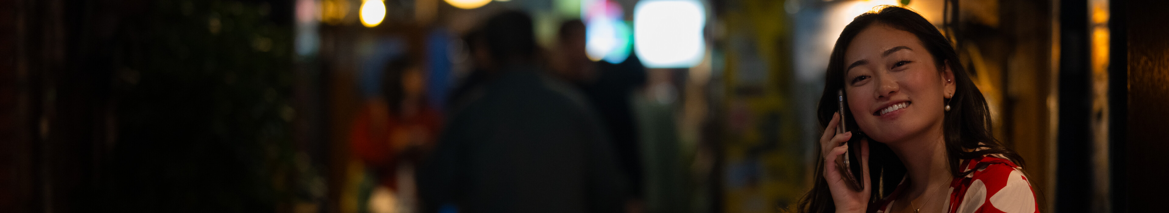 A woman talking on her phone on a street in Japan.