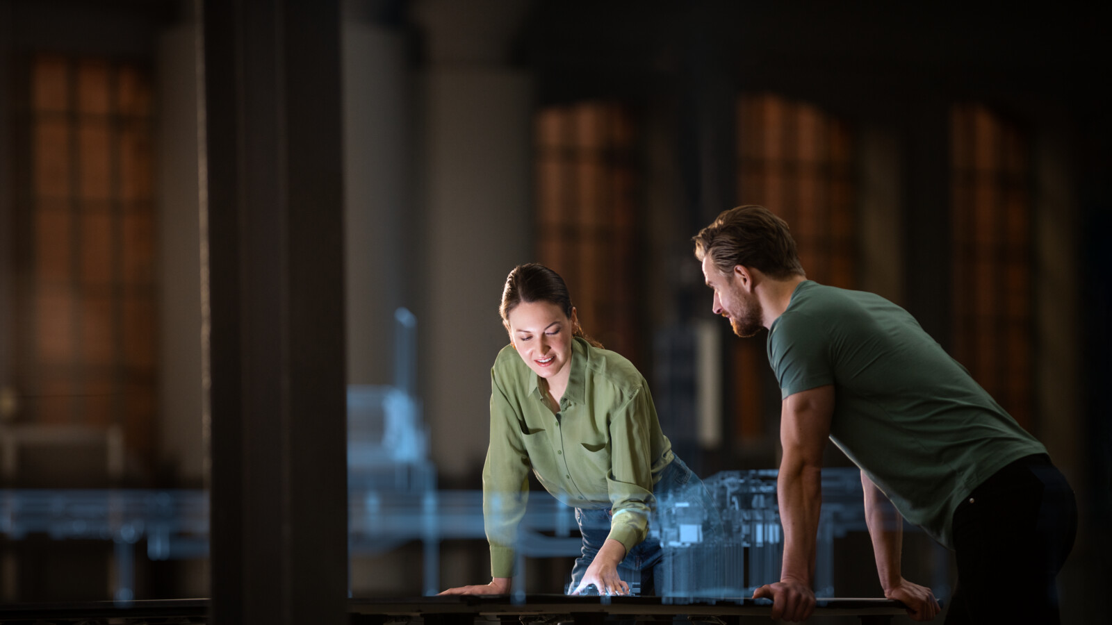 Colleagues discussing 5G industry project using a holographic model of a digital twin