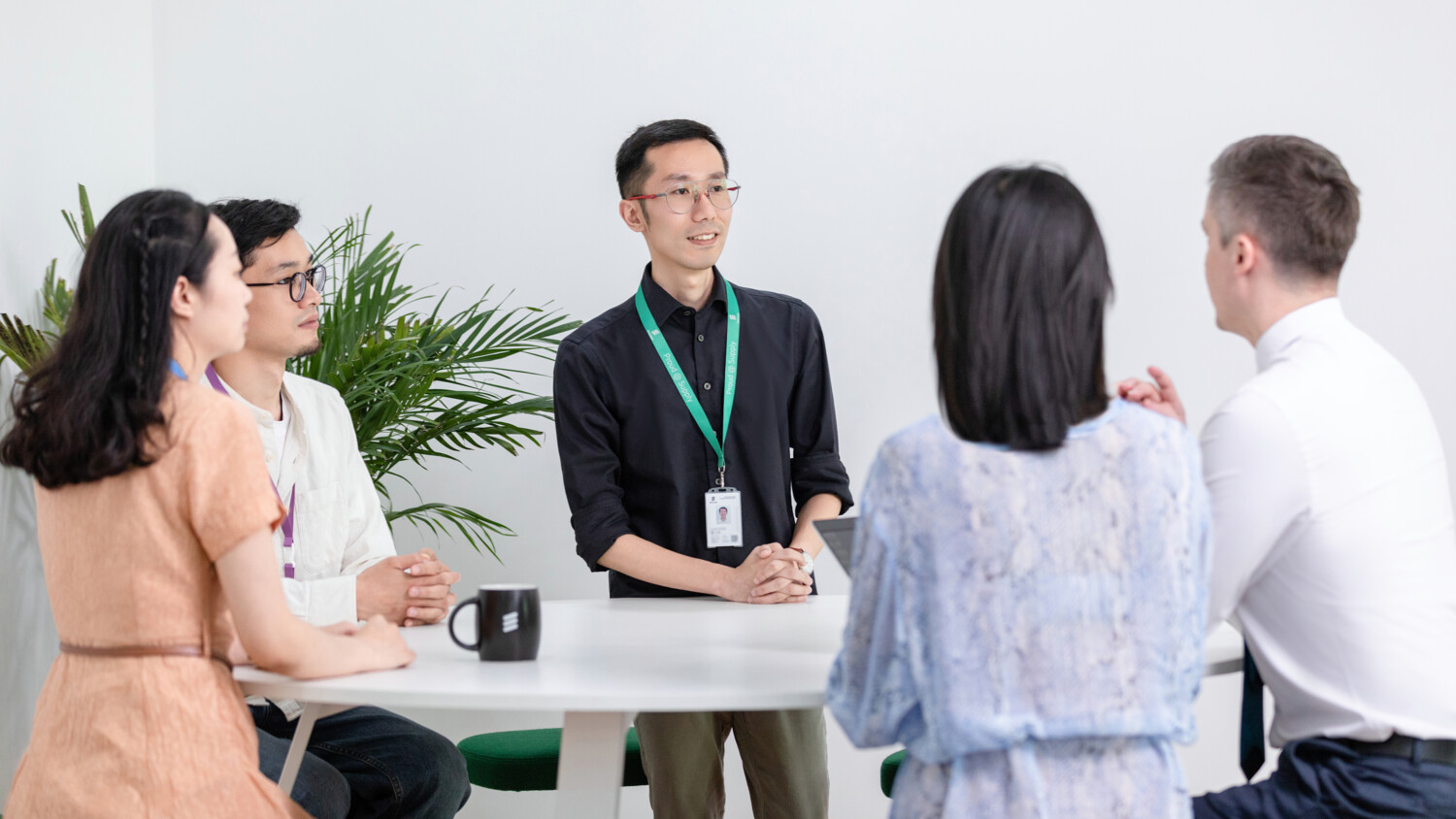 Ericsson 5G factory Nanjing people meeting around a table.