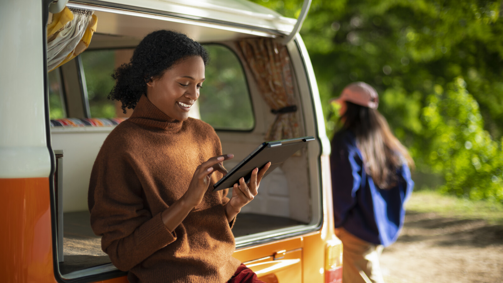 A woman using a tablet outside in nature