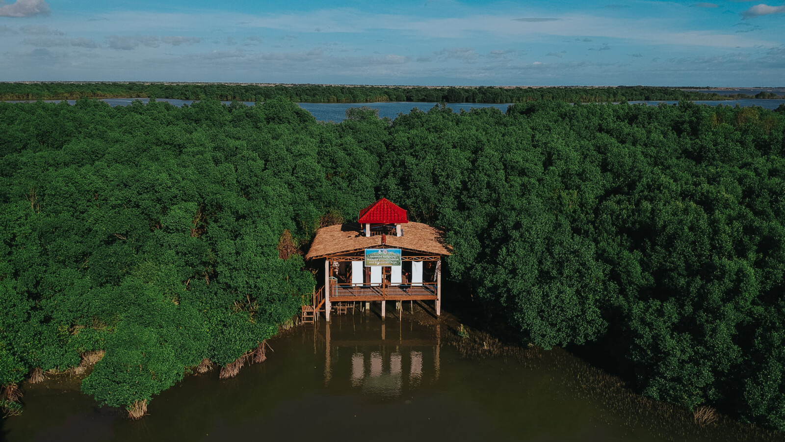 House surrounded by mangrove trees and water.