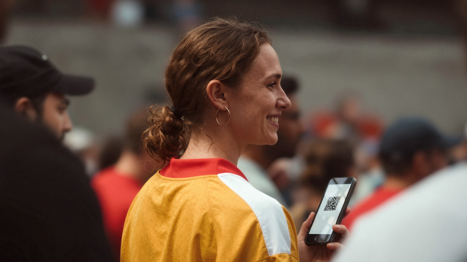 Fan showing digital ticket at sports event entrance.