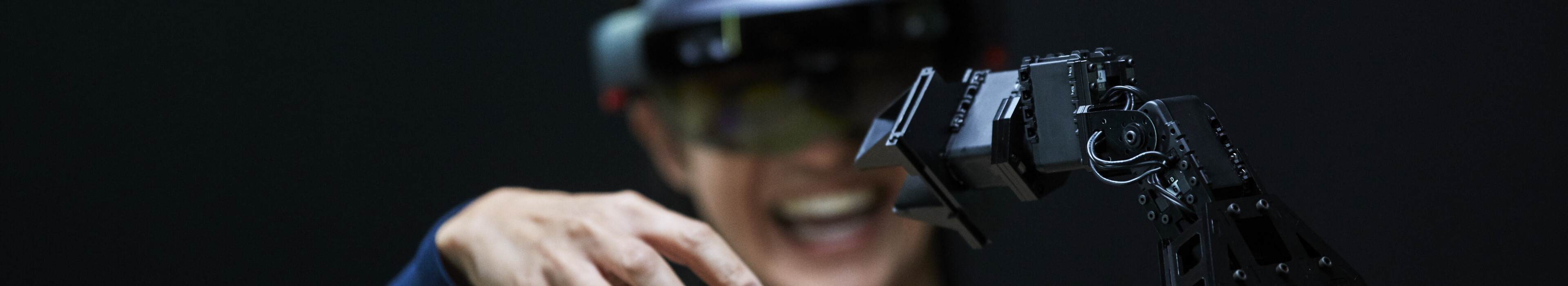 Woman using AR with robotic arm.