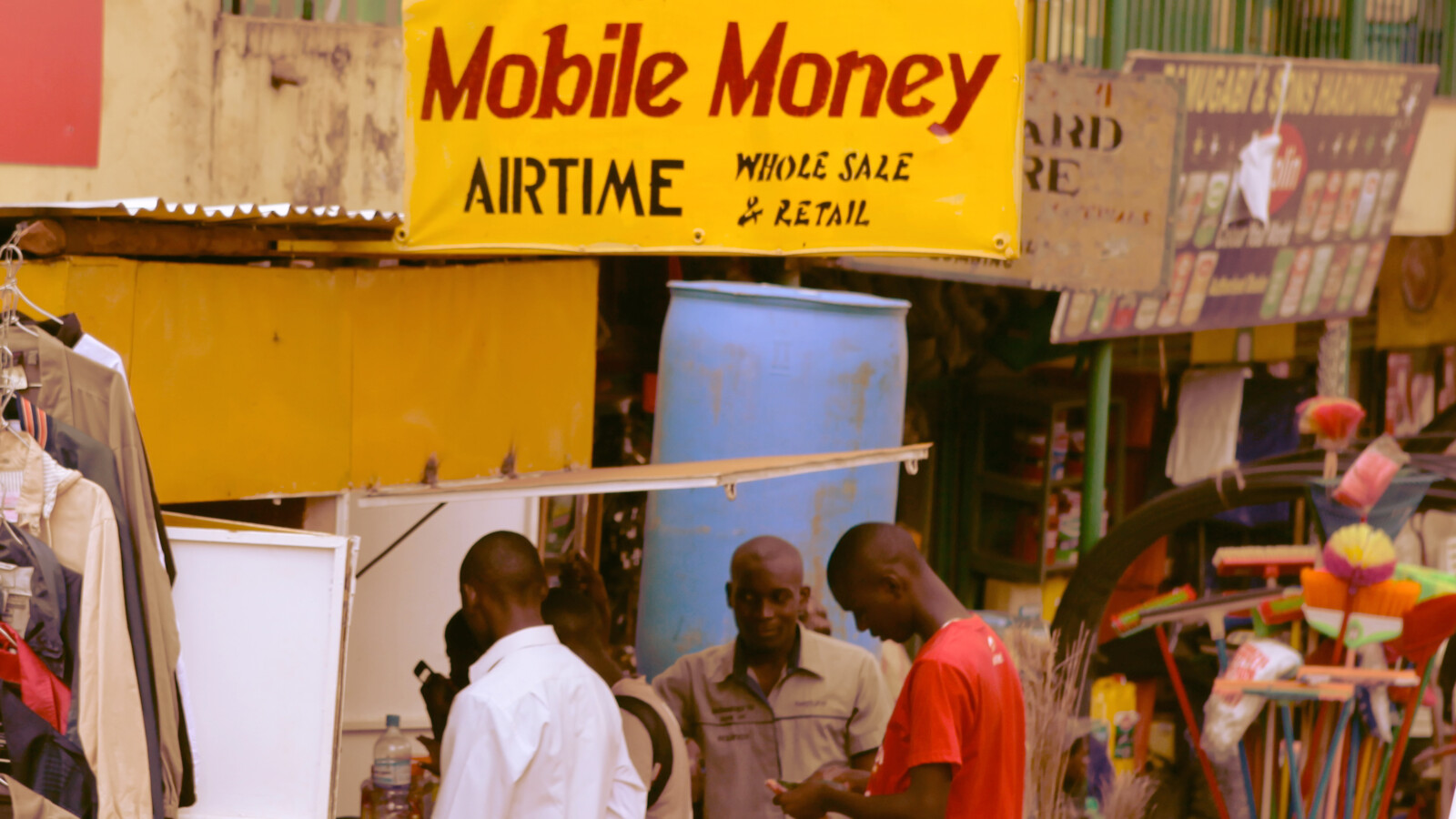 Street kiosk with mobile money and goods for sale.