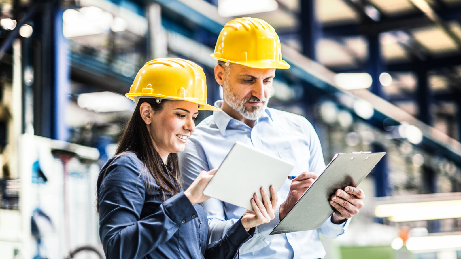 Two people in a warehouse using tablets.