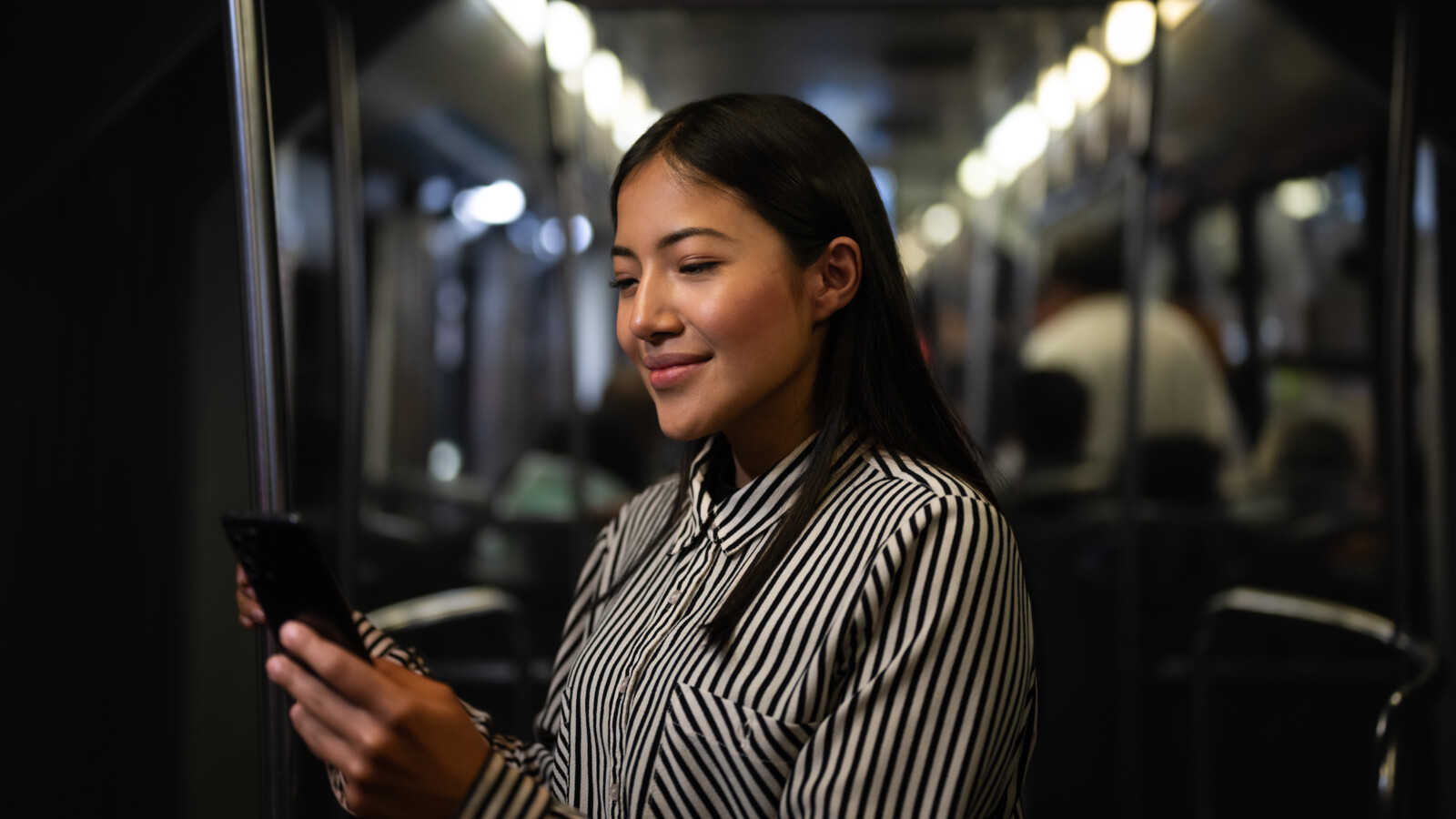 A woman checking her phone on public transport