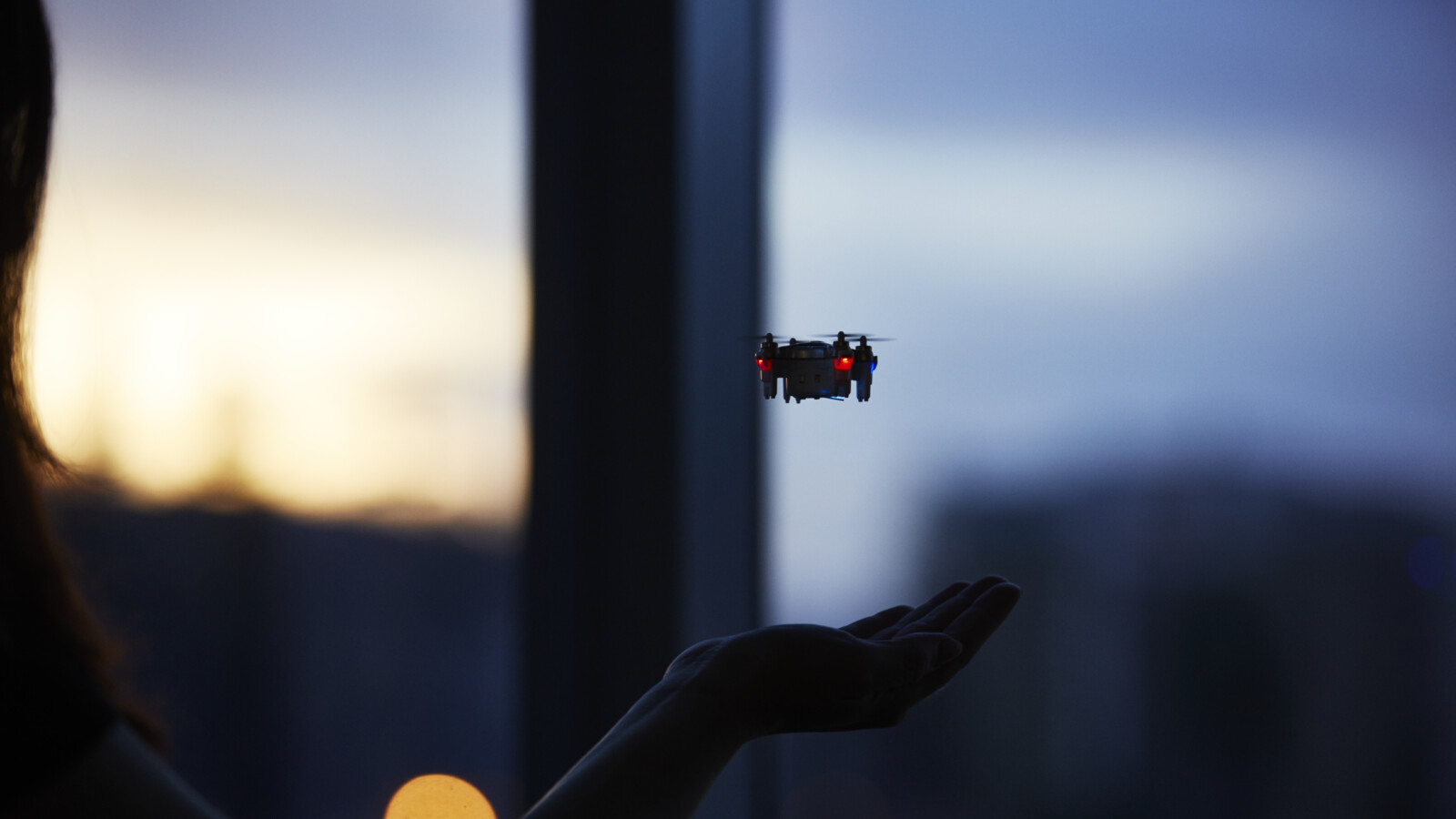 Women holding hand under drone.