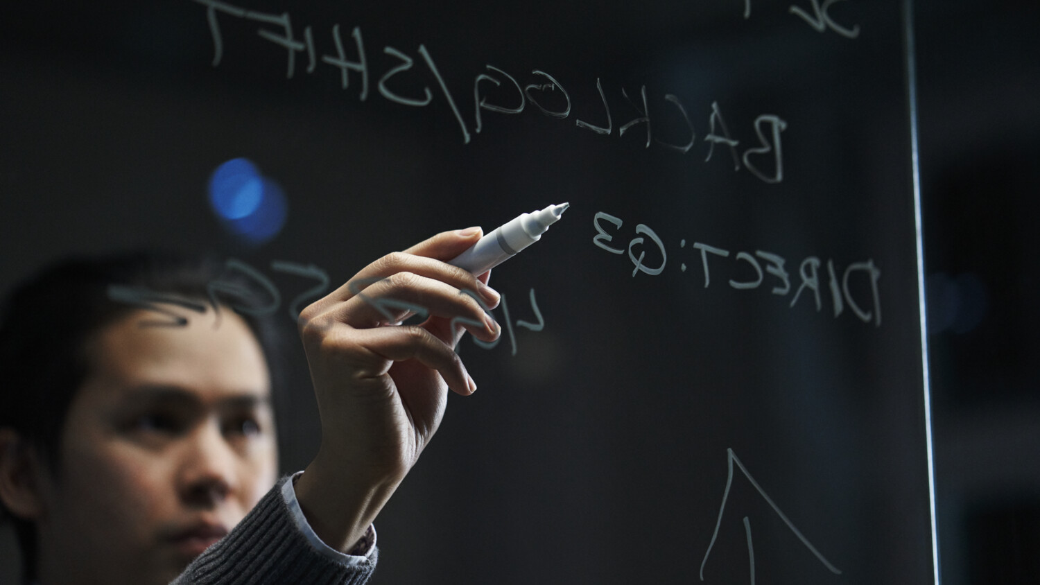Man writing on a glass wall