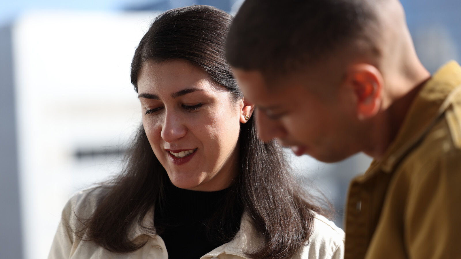 A man and a woman standing and looking at something.