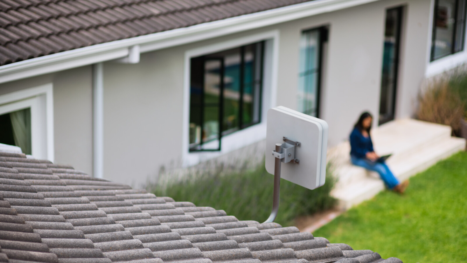 Woman working outdoor remotely with FWA router.