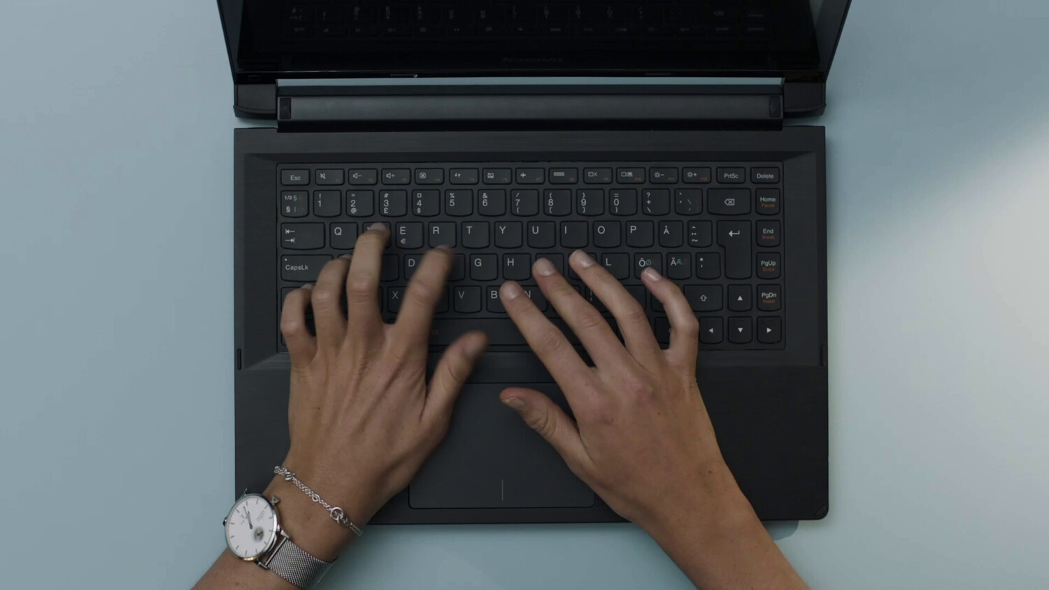 Hands on a laptop keyboard.
